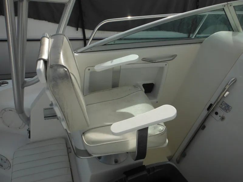Slide: The Image of 1999 Robalo 2440 Walkaround boat seat with white upholstery and armrests. - 38