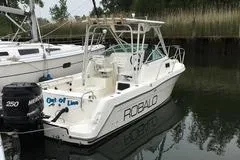 Slide: The Image of 1999 Robalo 2440 Walkaround boat docked in a marina. - 4