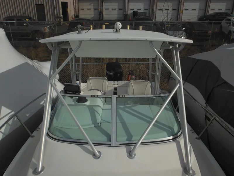 Slide: The Image of 1999 Robalo 2440 Walkaround boat with covered cockpit and windshield, docked outdoors. - 40