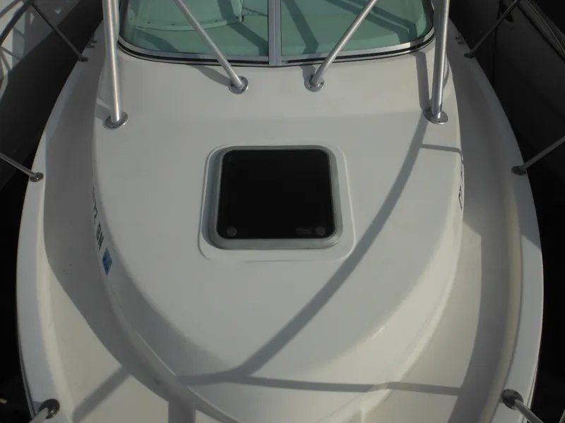 Slide: The Image of 1999 Robalo 2440 Walkaround boat deck with open hatch and railing. - 41
