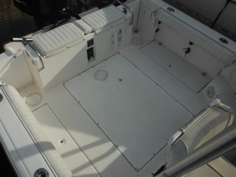 Slide: The Image of 1999 Robalo 2440 Walkaround boat deck, spacious and clean with seating and storage compartments. - 44