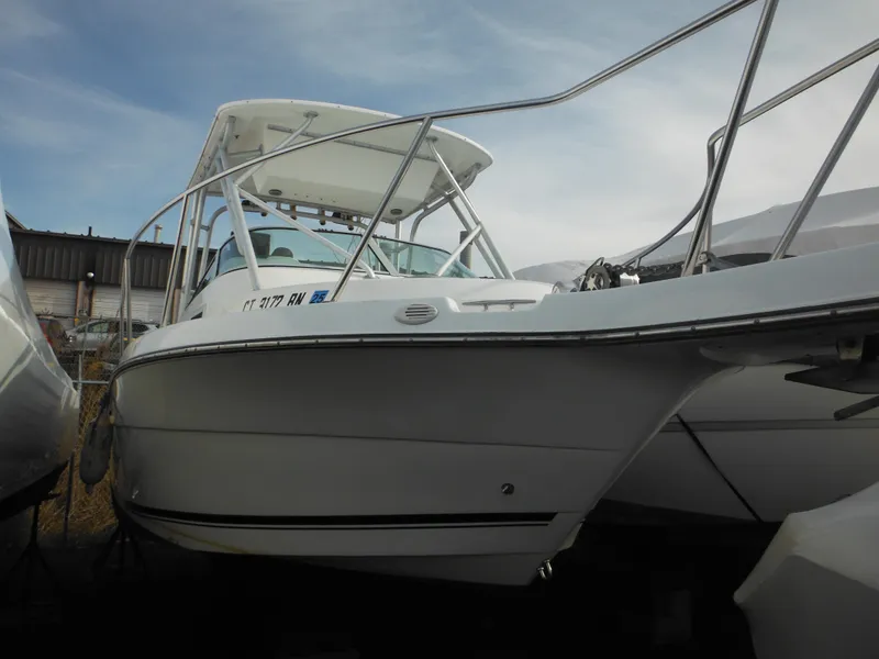 Slide: The Image of 1999 Robalo 2440 Walkaround boat with white hull, docked outdoors. - 49