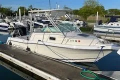 Slide: The Image of 1999 Robalo 2440 Walkaround boat docked in a marina. - 5