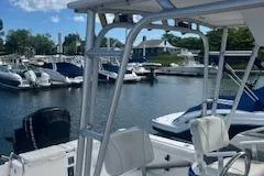 Slide: The Image of 1999 Robalo 2440 Walkaround boat docked in a marina with other vessels. - 7