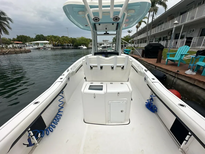 Slide: The Image of 2022 Tidewater 280 CC Adventure boat docked near waterfront homes. - 10