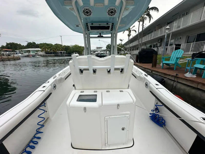 Slide: The Image of 2022 Tidewater 280 CC Adventure boat interior, docked by waterfront homes. - 11