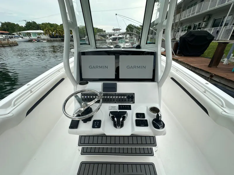 Slide: The Image of 2022 Tidewater 280 CC Adventure boat cockpit with Garmin displays and steering wheel. - 14