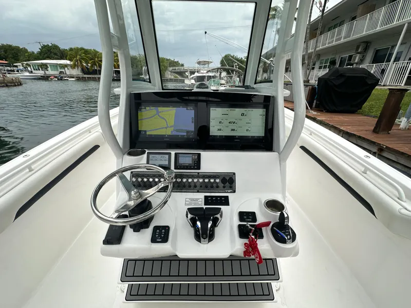 Slide: The Image of 2022 Tidewater 280 CC Adventure boat dashboard with navigation screens and controls. - 15