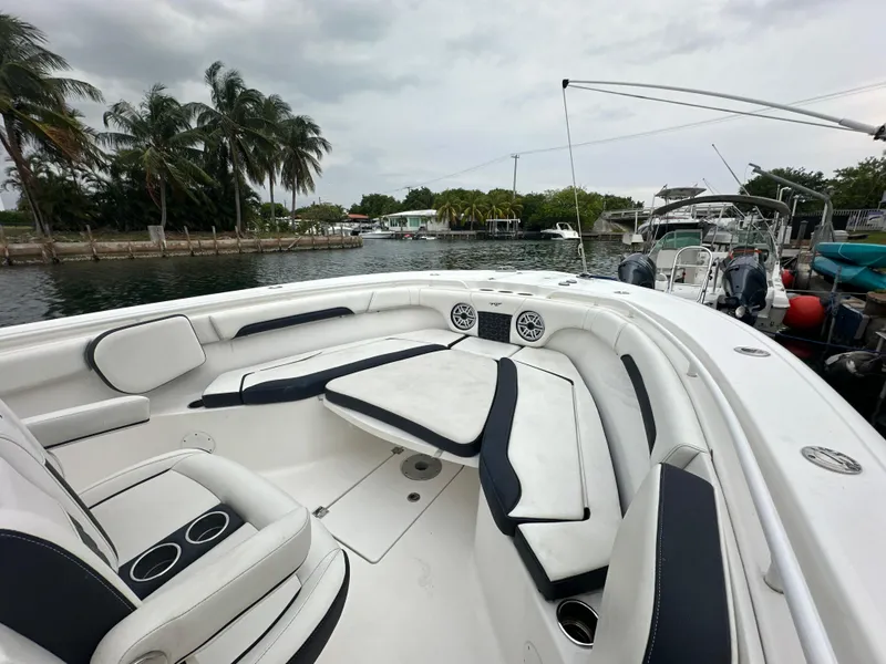 Slide: The Image of 2022 Tidewater 280 CC Adventure boat with spacious seating, docked near palm trees. - 17