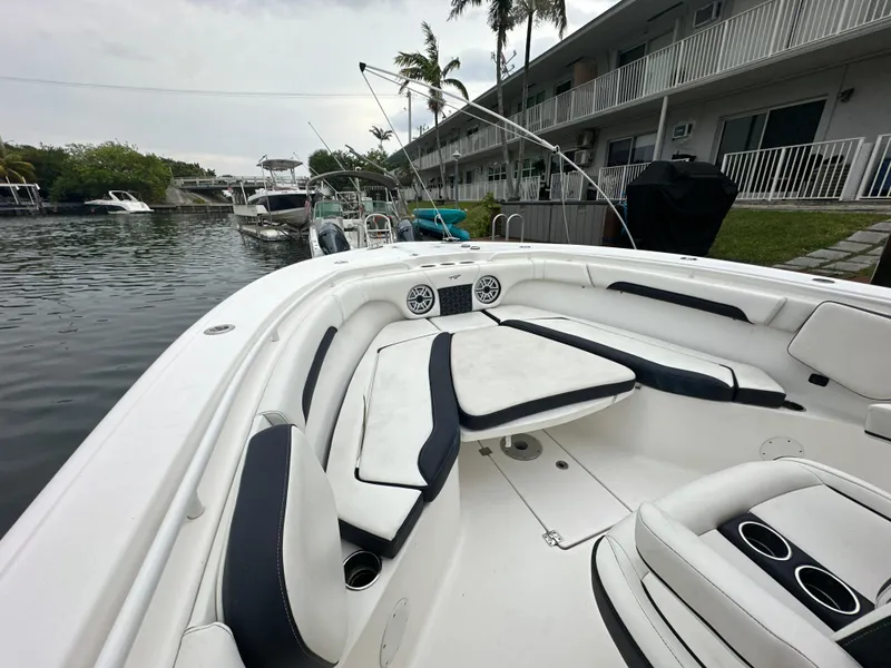 Slide: The Image of 2022 Tidewater 280 CC Adventure boat with spacious seating, docked near waterfront homes. - 18