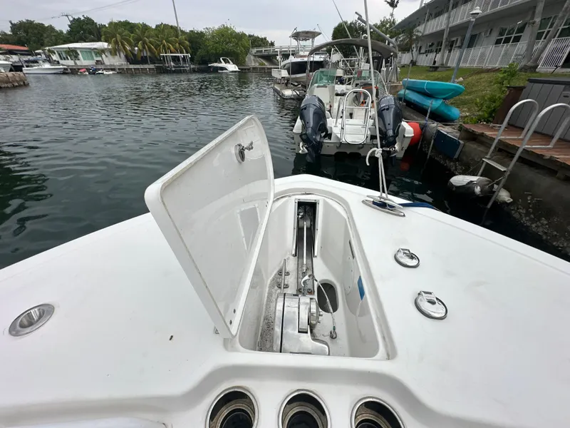 Slide: The Image of 2022 Tidewater 280 CC Adventure boat with open anchor compartment, docked in a marina. - 20
