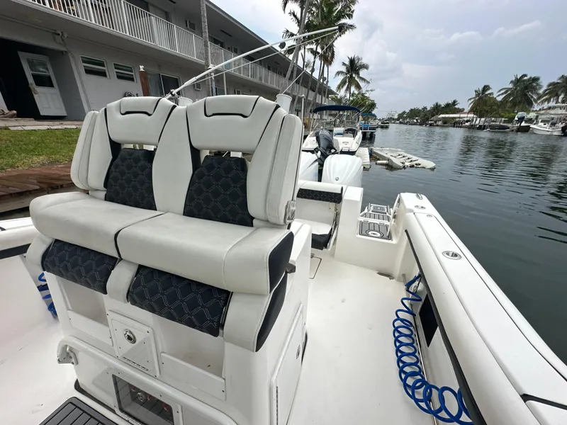 Slide: The Image of 2022 Tidewater 280 CC Adventure boat with dual seats, docked by a canal. - 23