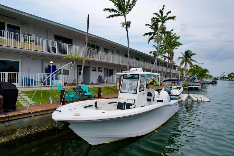 Slide: The Image of 2022 Tidewater 280 CC Adventure boat docked by waterfront apartments. - 3
