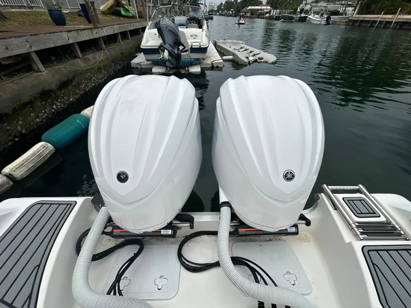 Slide: The Image of Twin outboard engines on a 2022 Tidewater 280 CC Adventure boat docked by the water. - 4