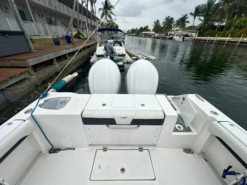 Slide: The Image of 2022 Tidewater 280 CC Adventure boat docked in a canal with twin engines. - 5