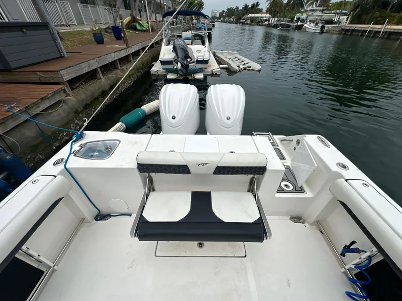 Slide: The Image of 2022 Tidewater 280 CC Adventure boat docked, featuring dual outboard engines and spacious seating. - 9