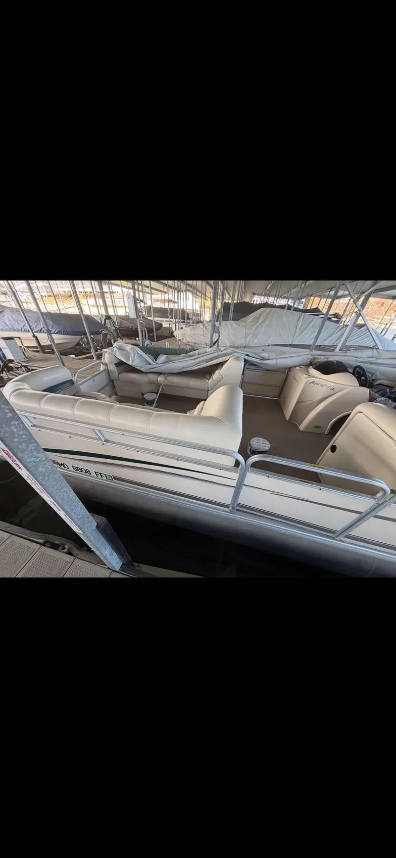 Slide: The Image of 2005 Godfrey AquaPatio 240 LE pontoon boat with beige seating, docked in a marina. - 10