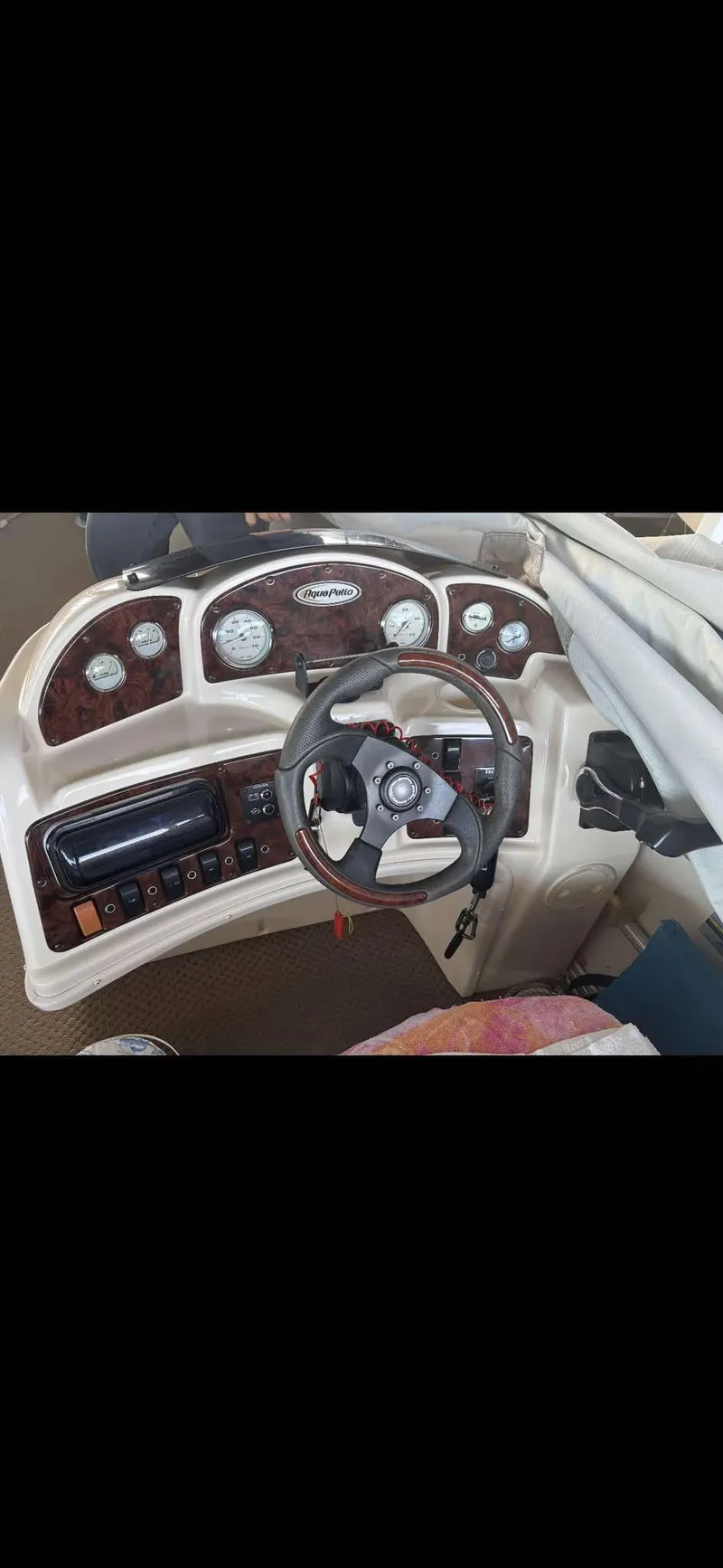 Slide: The Image of 2005 Godfrey AquaPatio 240 LE boat dashboard with steering wheel and gauges. - 15