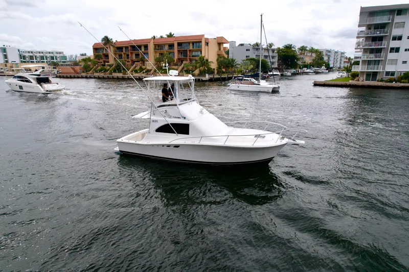 Slide: The Image of 1993 Luhrs 320 Tournament boat cruising in a marina with other vessels nearby. - 3