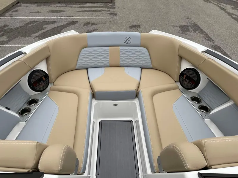 Slide: The Image of 2023 MasterCraft X24 boat interior with beige and gray seating, featuring built-in speakers. - 11