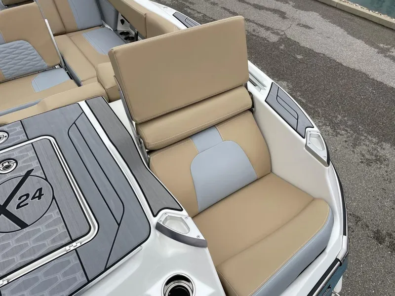 Slide: The Image of 2023 MasterCraft X24 boat interior with beige and gray seating, showcasing luxury design. - 13