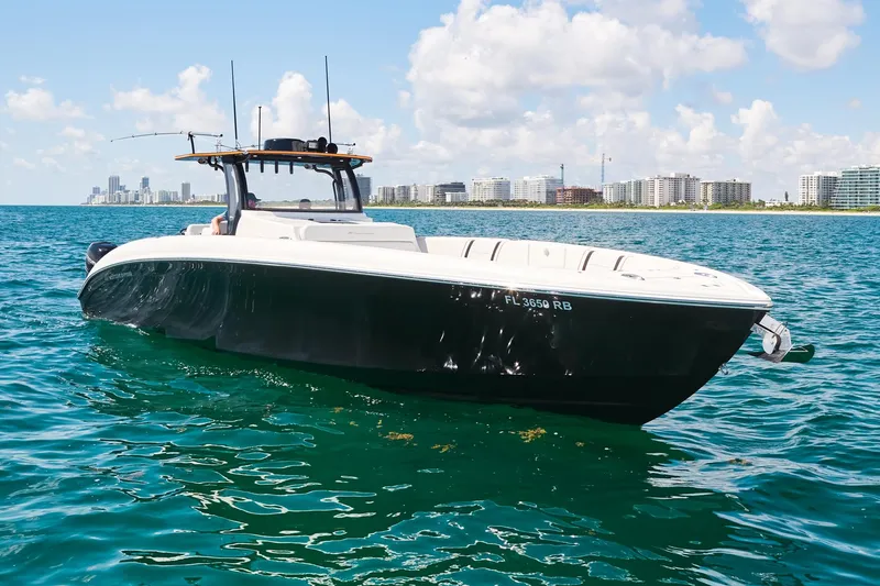 Slide: The Image of 2016 Midnight Express 43' Open boat on clear blue water, city skyline in background. - 13