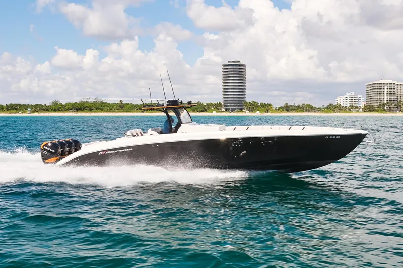 Slide: The Image of 2016 Midnight Express 43' Open boat cruising on the water with cityscape background. - 6