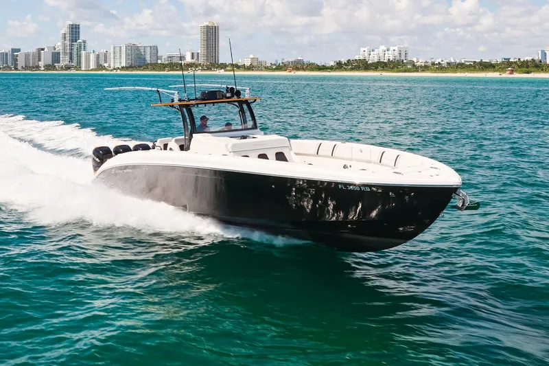 Slide: The Image of 2016 Midnight Express 43' Open boat cruising on clear blue water near a city skyline. - 7