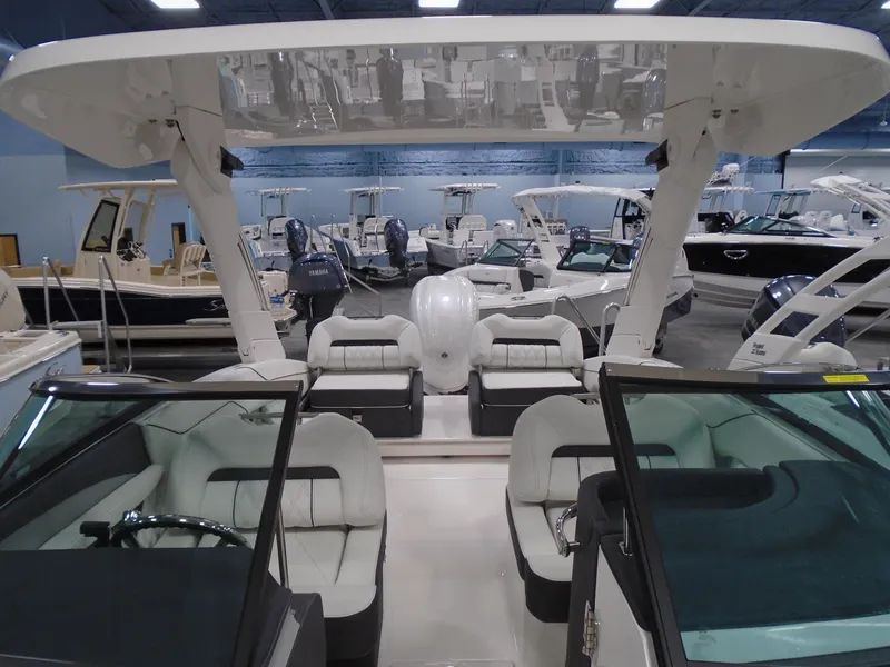 Slide: The Image of 2025 Regal LX4 boat interior with white seating, displayed in a showroom. - 15
