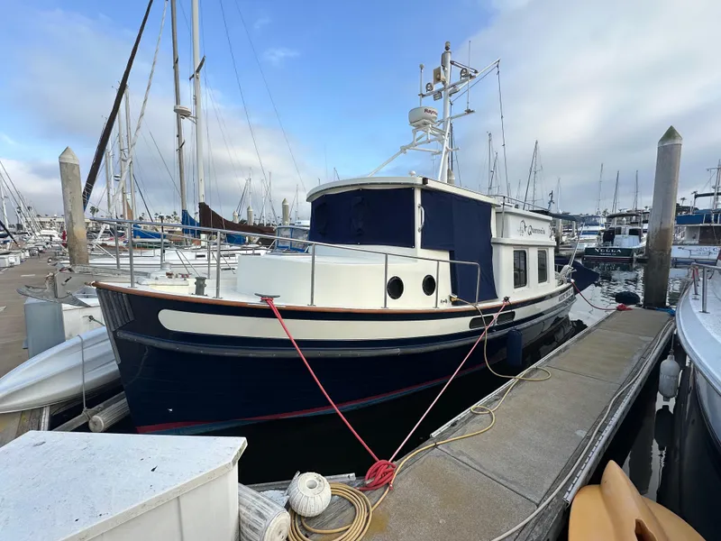 Slide: The Image of 1996 Nordic Tug 32 docked at a marina, featuring classic design and sturdy build. - 1