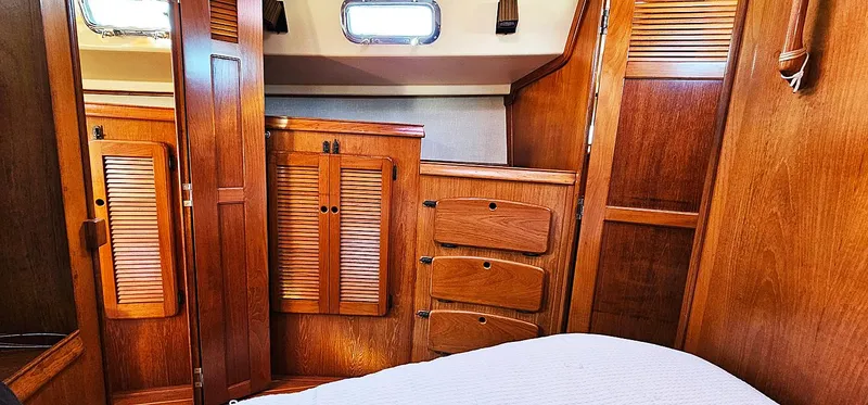 Slide: The Image of 1988 Island Packet 38 cabin interior with wooden cabinetry and cozy bed. - 7