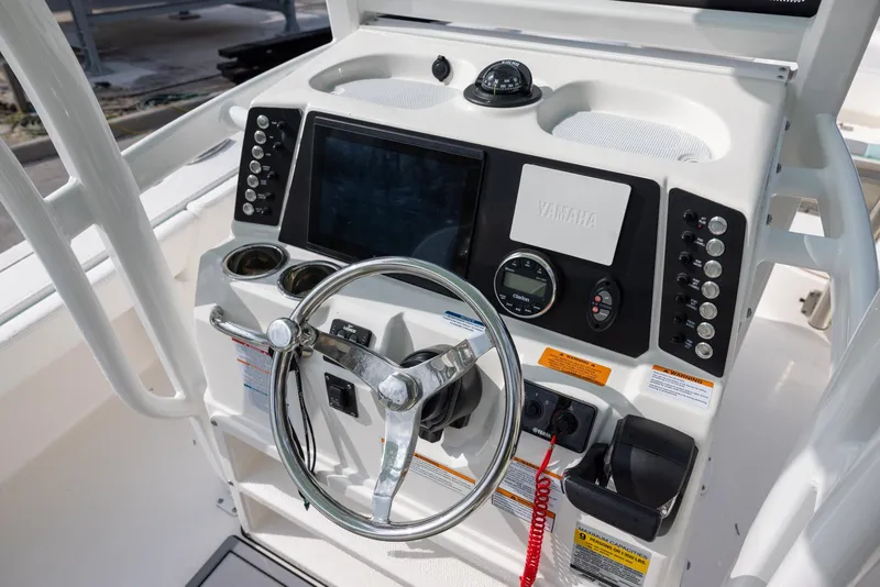 Slide: The Image of 2023 Robalo 246 Cayman boat dashboard with steering wheel and control panel. - 12