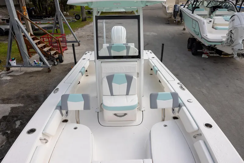 Slide: The Image of 2023 Robalo 246 Cayman boat interior with seating and console, docked outdoors. - 15