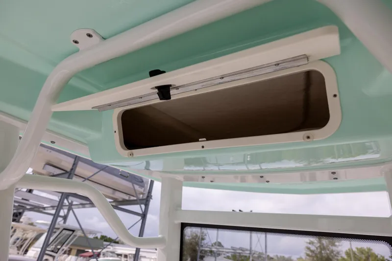 Slide: The Image of 2023 Robalo 246 Cayman boat storage compartment, open and empty, with a light blue interior. - 18