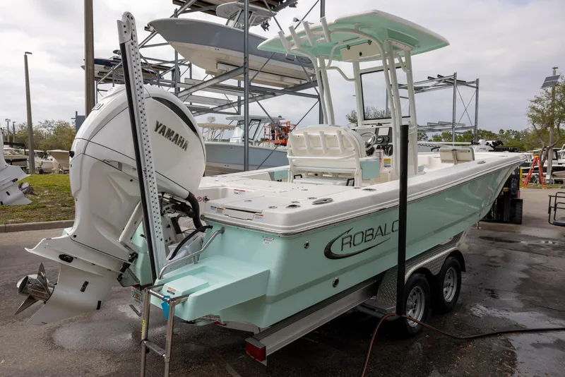 Slide: The Image of 2023 Robalo 246 Cayman boat with Yamaha engine on trailer in marina setting. - 4
