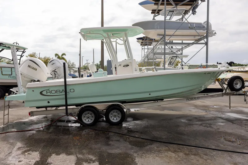 Slide: The Image of 2023 Robalo 246 Cayman boat on trailer, mint green hull, parked outdoors. - 5