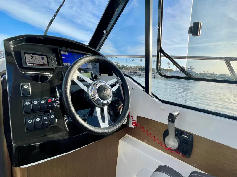 Slide: The Image of 2020 Jeanneau NC 795 boat cockpit with steering wheel and control panel. - 13