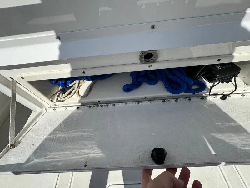 Slide: The Image of Open storage compartment on a 1996 Intrepid 356 Cuddy boat with ropes and equipment. - 15