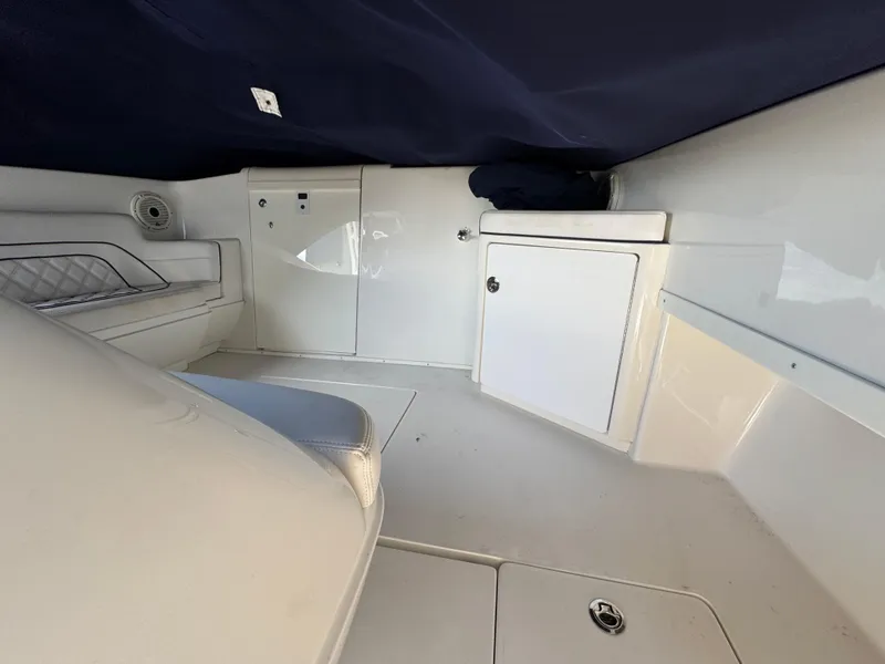 Slide: The Image of Interior of a 1996 Intrepid 356 Cuddy boat, featuring white cabinetry and seating. - 16