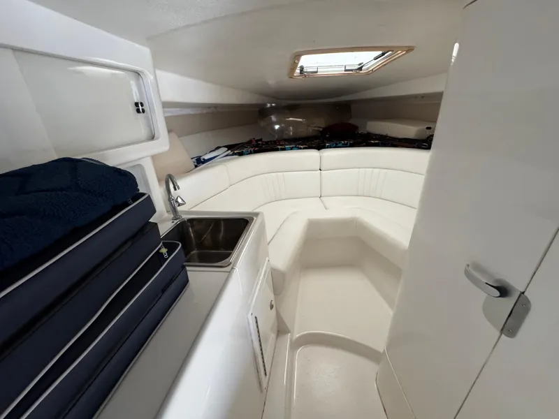 Slide: The Image of Interior of a 1996 Intrepid 356 Cuddy boat, featuring a cozy seating area and compact sink. - 17