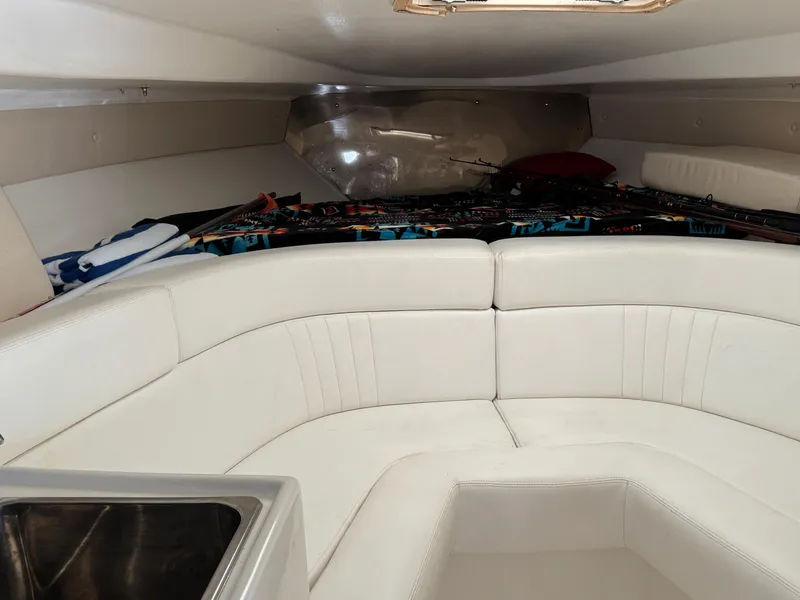 Slide: The Image of Interior of a 1996 Intrepid 356 Cuddy boat with white seating and fishing gear. - 18