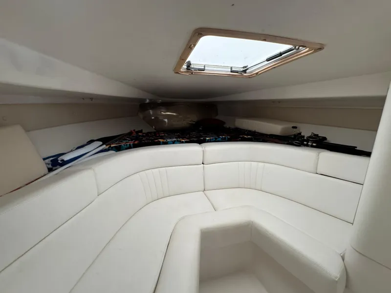 Slide: The Image of Interior of a 1996 Intrepid 356 Cuddy boat with white seating and overhead hatch. - 19