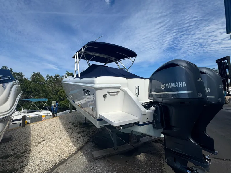 Slide: The Image of 1996 Intrepid 356 Cuddy boat with Yamaha engines, docked under a blue sky. - 2