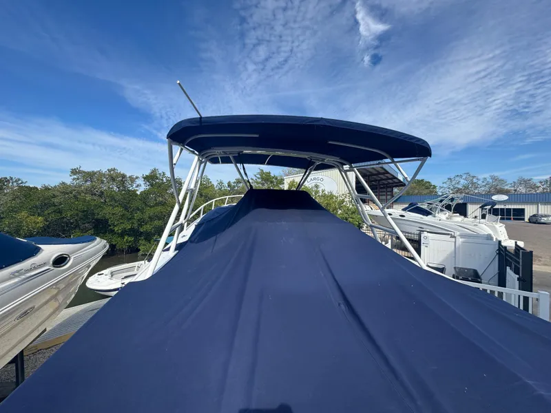 Slide: The Image of 1996 Intrepid 356 Cuddy boat with blue cover, docked under a clear sky. - 5