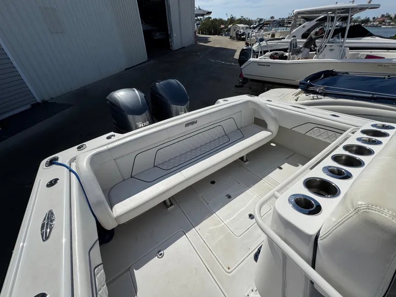 Slide: The Image of 1996 Intrepid 356 Cuddy boat interior with seating and cup holders, docked near other boats. - 9