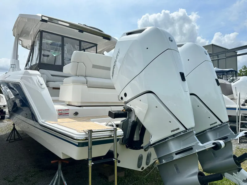 Slide: The Image of 2025 Tiara Yachts 34 LS with dual outboard engines, docked under a sunny sky. - 12