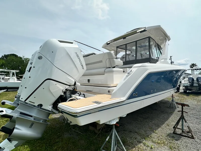 Slide: The Image of 2025 Tiara Yachts 34 LS with Mercury outboard, docked on land, rear view. - 13