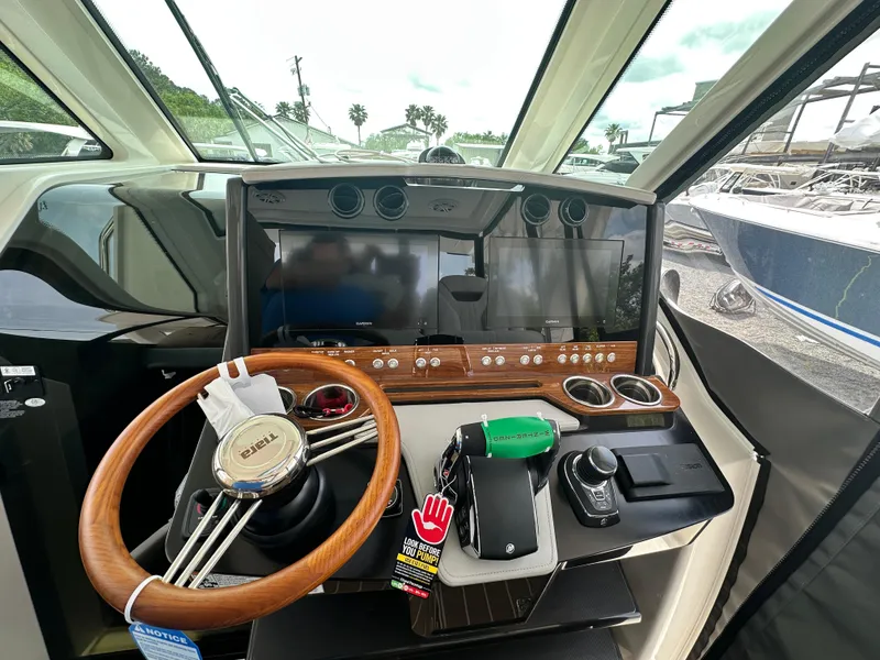 Slide: The Image of 2025 Tiara Yachts 34 LS helm with modern controls and wooden steering wheel. - 30
