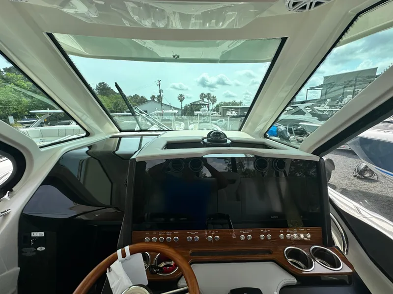 Slide: The Image of Interior view of 2025 Tiara Yachts 34 LS, featuring modern dashboard and steering wheel. - 31