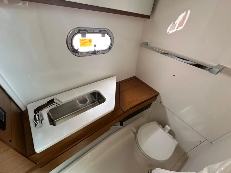 Slide: The Image of 2025 Tiara Yachts 34 LS bathroom with sink, toilet, and porthole window. - 36